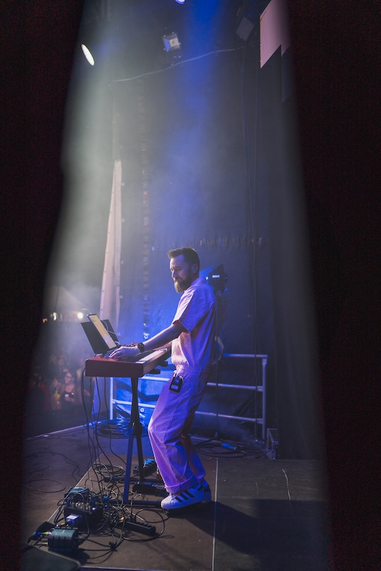 Keyboarder der Partyband spielt live auf der Bühne bei Festival