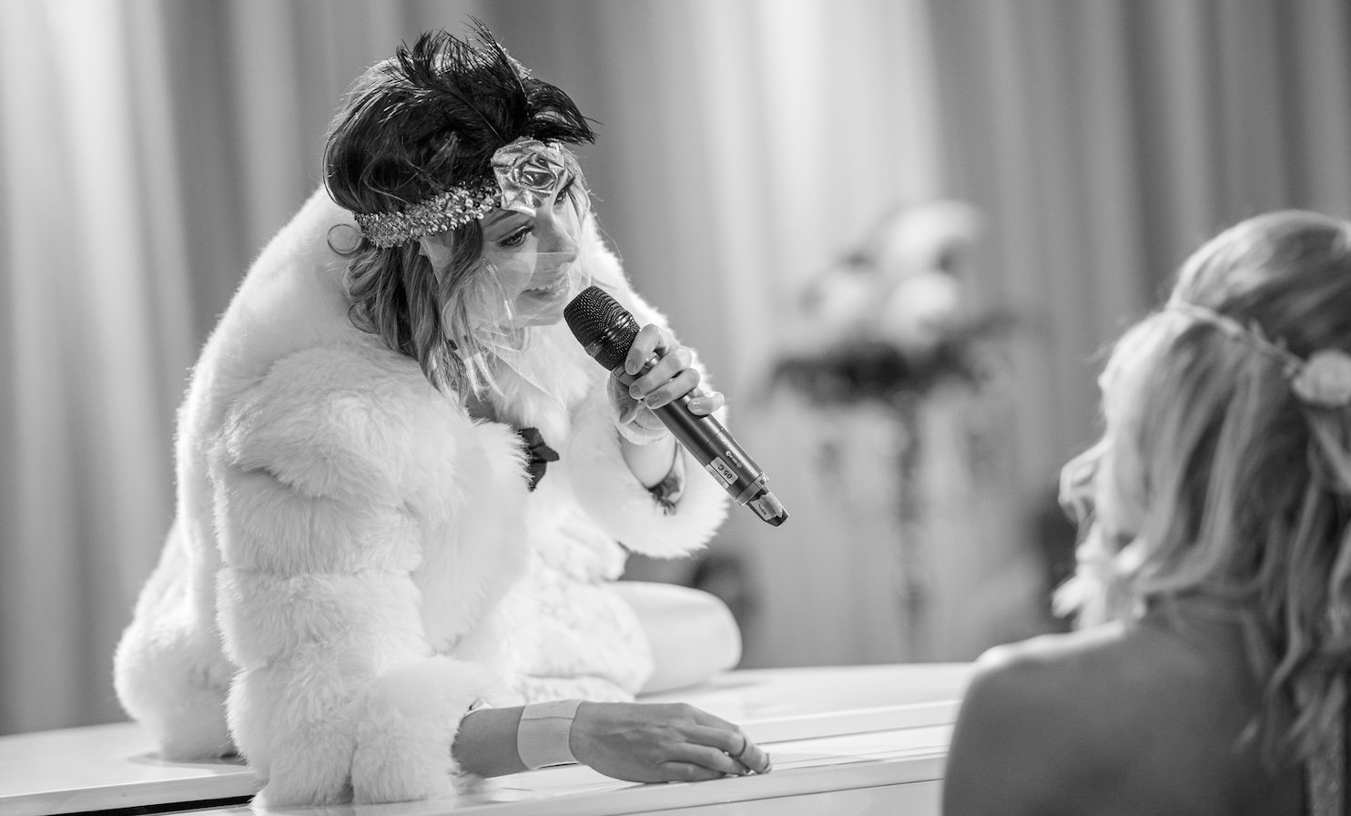 Elegante Hochzeitssängerin singt live auf fahrendem Flügel während des Abendessens bei einer Hochzeit