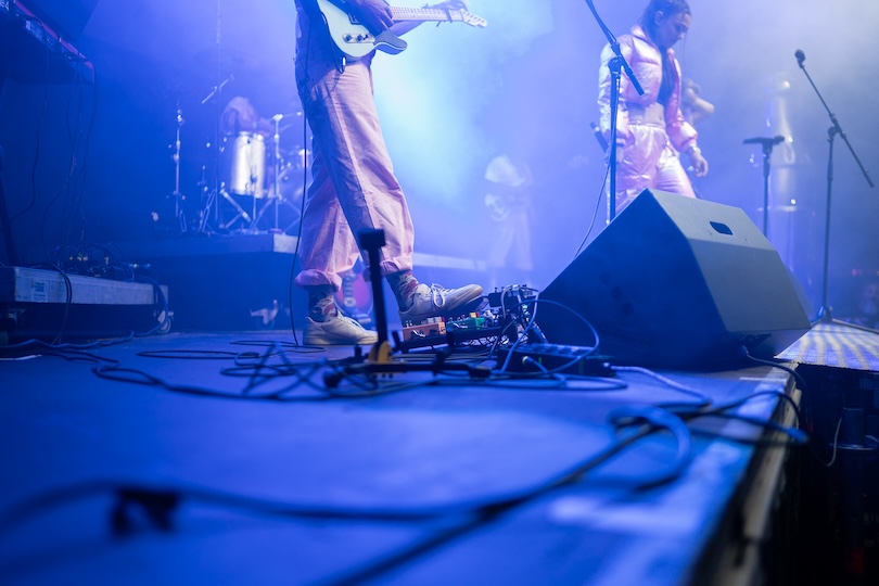 Gitarrist der Partyband Covered Luzern spielt live mit Fußpedal auf Bühne